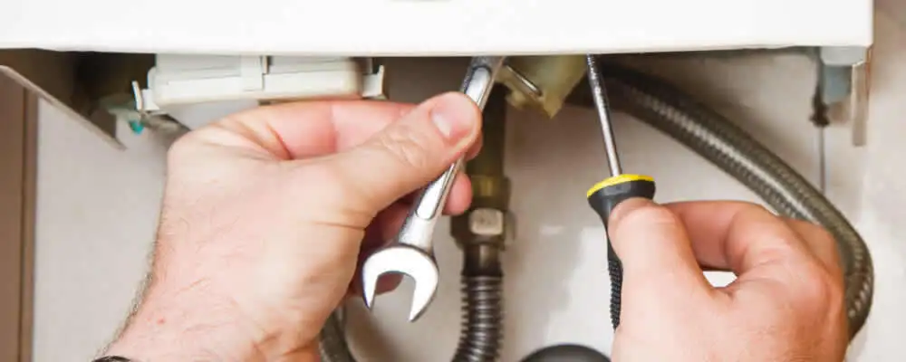 Boiler repair technician tightening pipe fittings and connections in Flagstaff, AZ