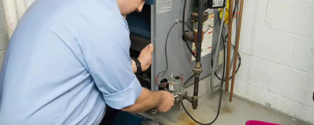 Furnace repair technician inspecting and servicing a home heating system in Flagstaff, AZ