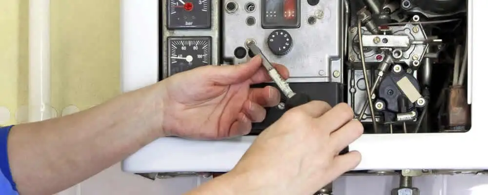 Heating repair technician adjusting boiler controls and components in Flagstaff, AZ