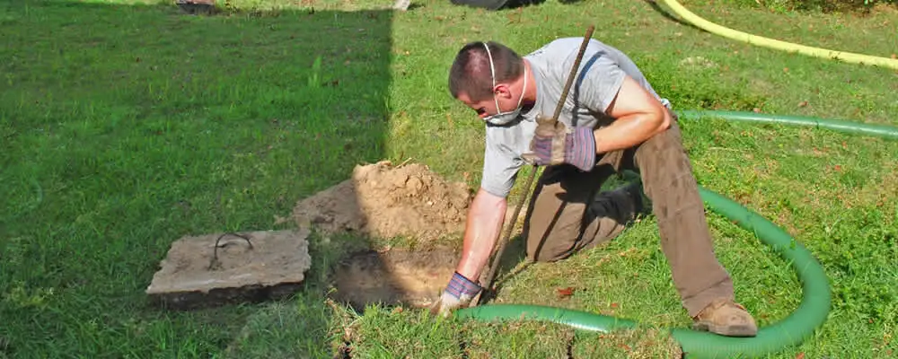 Septic pumping technician servicing a residential septic tank in Flagstaff, AZ