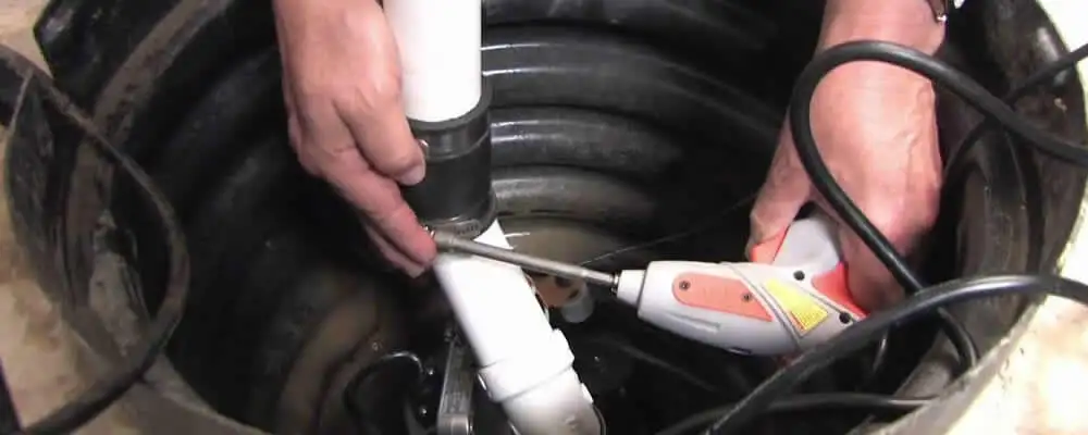 Sump pump installation technician connecting PVC discharge piping in Flagstaff, AZ