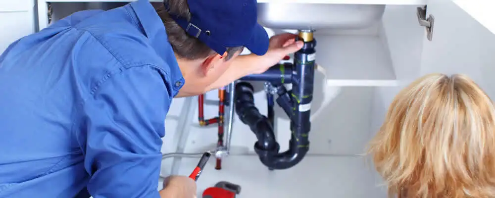 Plumber repairing under-sink drain pipes and fittings in Flagstaff, AZ